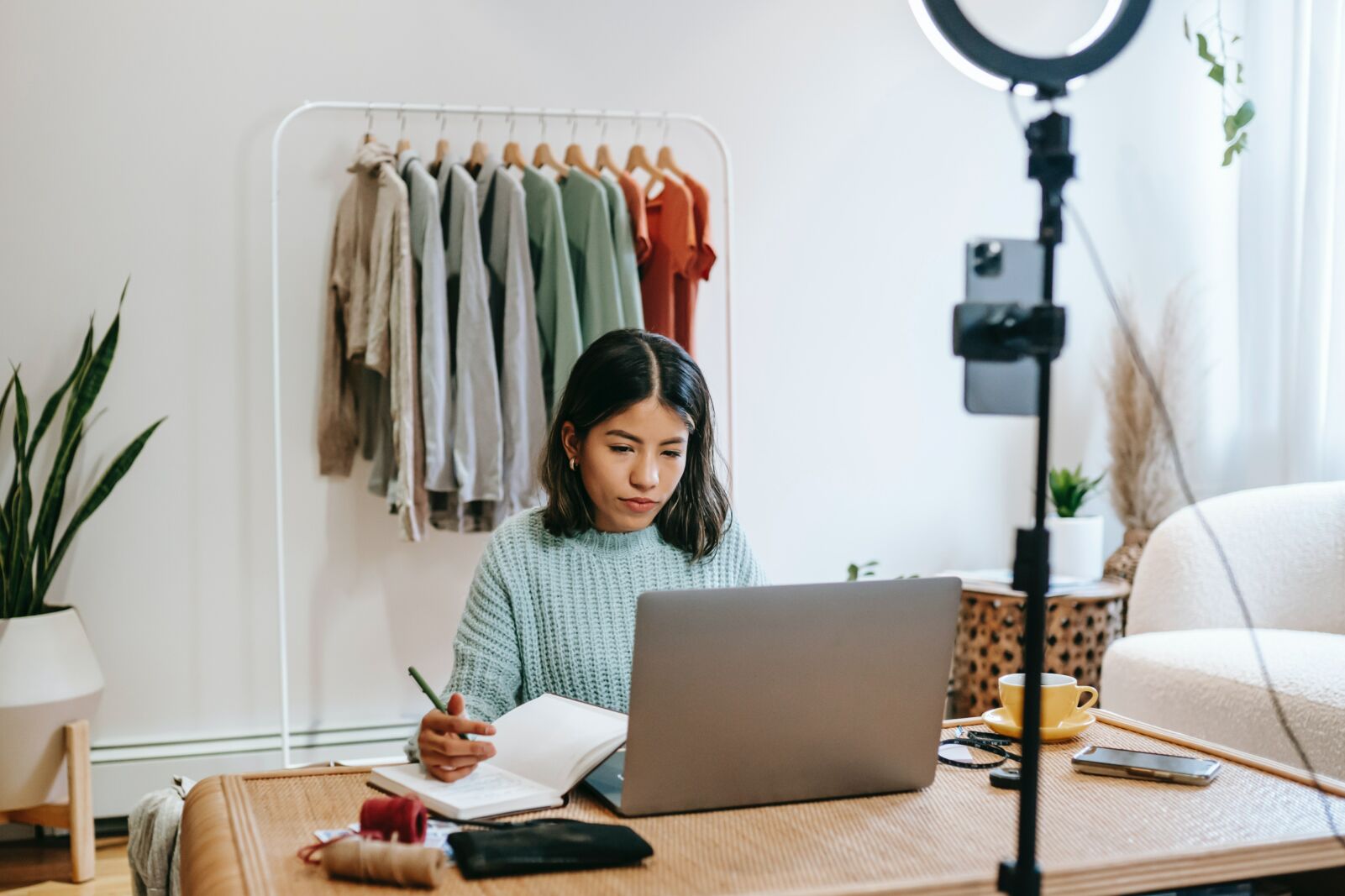 Image shows a girl on her laptop, taking notes, with a ring light set up in front of her